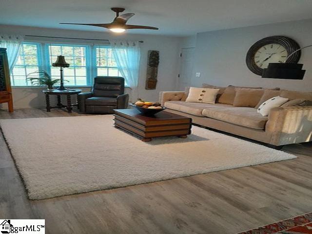 living room with ceiling fan and wood finished floors