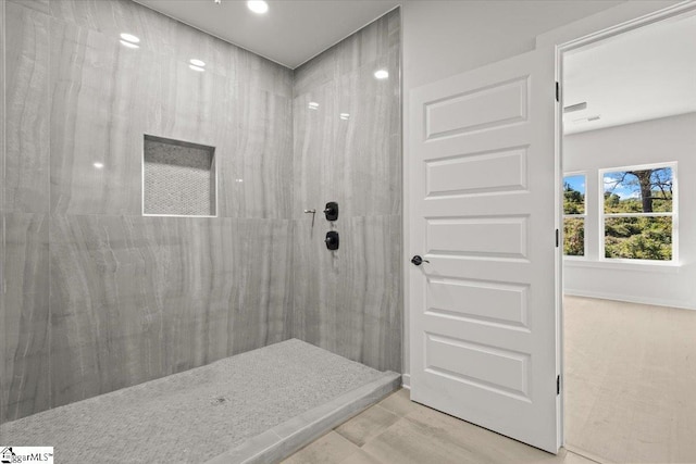 bathroom featuring tiled shower and wood finished floors