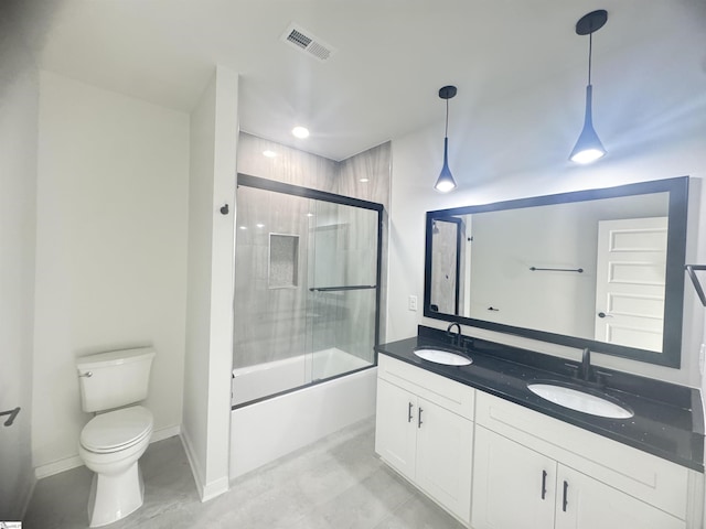 bathroom featuring toilet, combined bath / shower with glass door, a sink, and visible vents