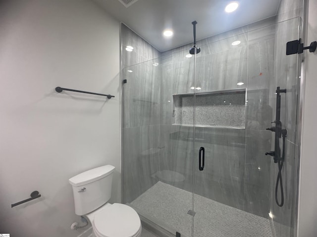 bathroom with a shower stall and toilet