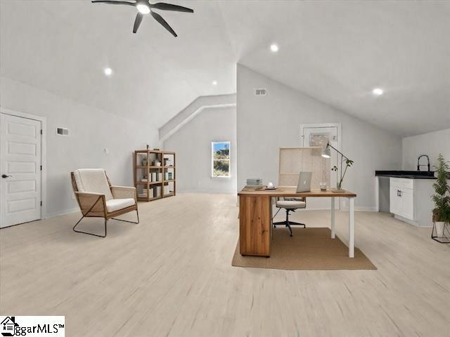 office space featuring a ceiling fan, vaulted ceiling, a sink, and wood finished floors