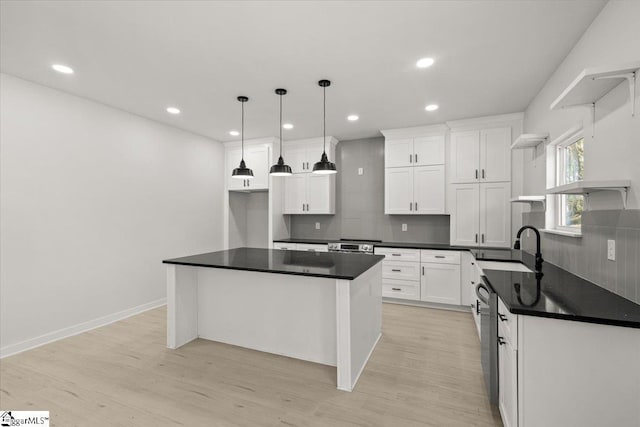 kitchen featuring open shelves, dark countertops, a sink, and white cabinets