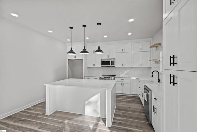 kitchen with appliances with stainless steel finishes, a sink, white cabinetry, open shelves, and backsplash