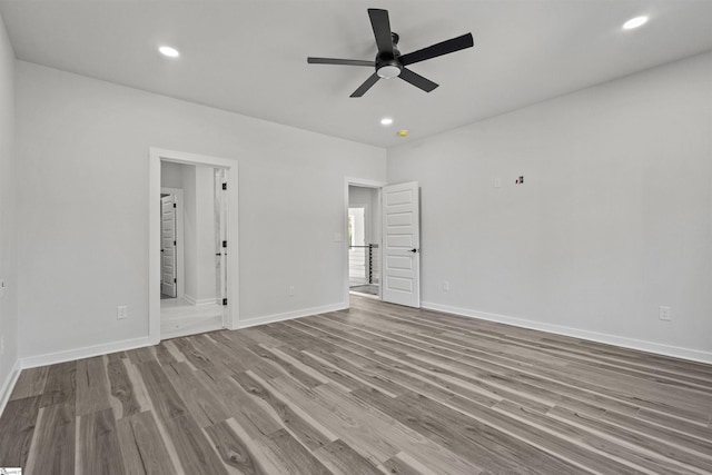 spare room featuring a ceiling fan, baseboards, wood finished floors, and recessed lighting