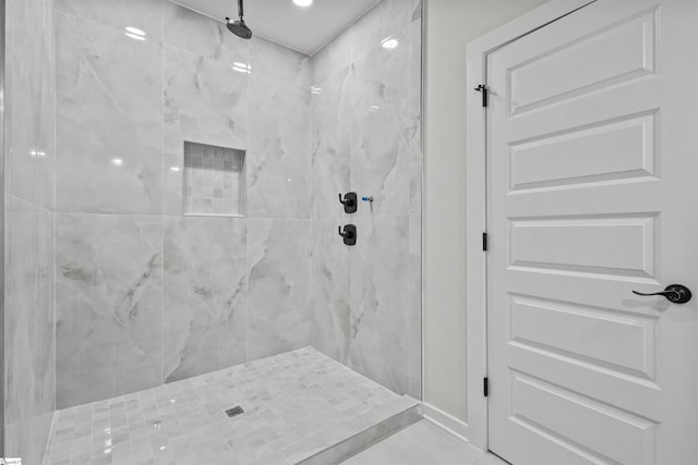 bathroom featuring a marble finish shower