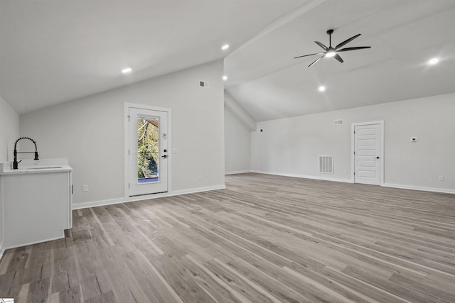 bonus room with visible vents, light wood-style flooring, vaulted ceiling, a sink, and baseboards