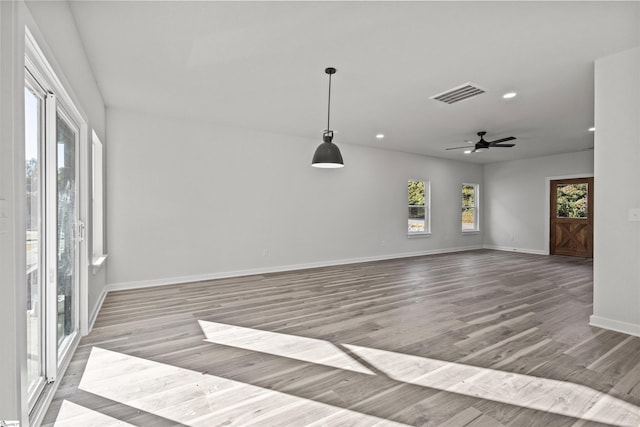 empty room featuring ceiling fan, recessed lighting, wood finished floors, visible vents, and baseboards