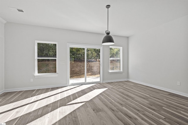 interior space featuring wood finished floors, visible vents, and baseboards