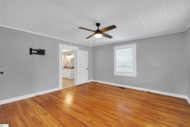 unfurnished bedroom with light wood-style floors, crown molding, and baseboards