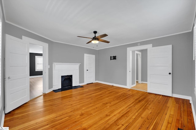 unfurnished living room with light wood-type flooring, a fireplace, and crown molding