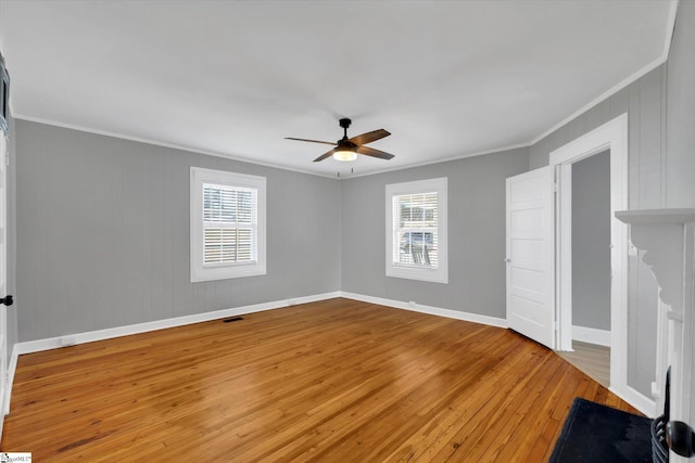 interior space featuring ornamental molding, light wood-type flooring, a healthy amount of sunlight, and baseboards