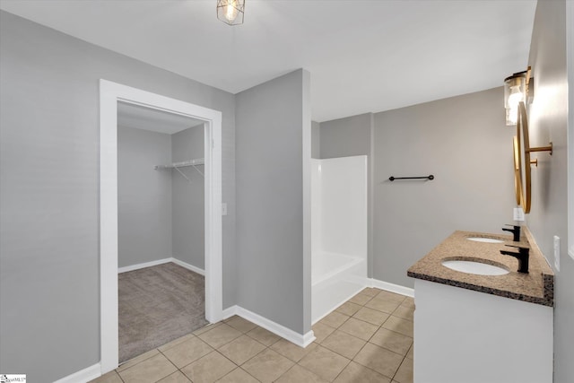 bathroom featuring baseboards, a sink, and tile patterned floors