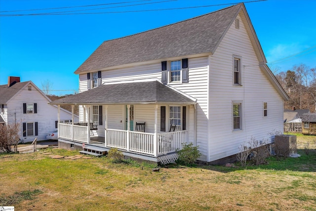 view of front facade with a shingled roof, a front yard, covered porch, and central air condition unit