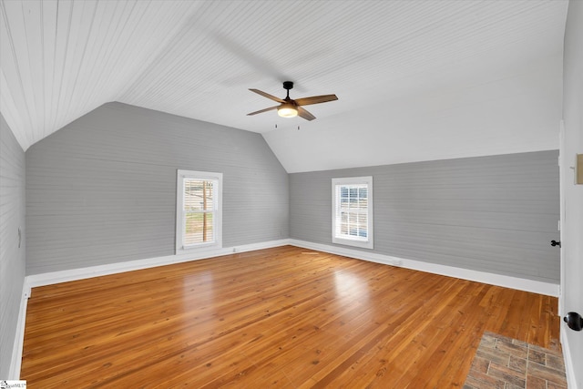 bonus room featuring vaulted ceiling, ceiling fan, hardwood / wood-style flooring, and baseboards