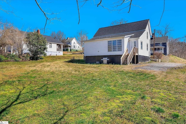 rear view of property with a yard and driveway