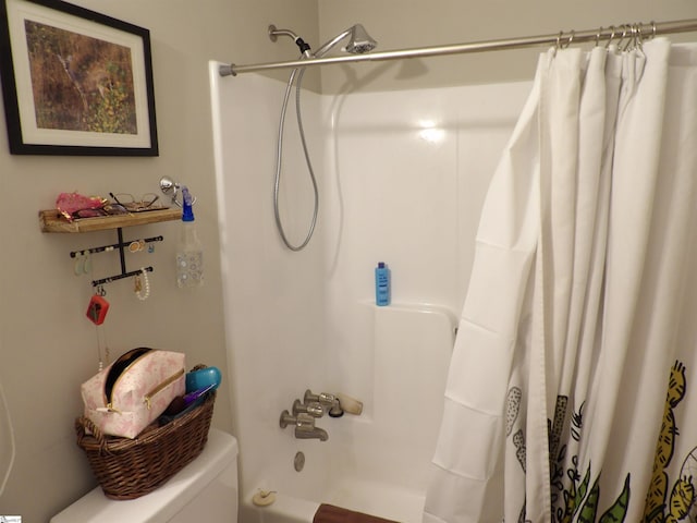 bathroom featuring shower / tub combo and toilet