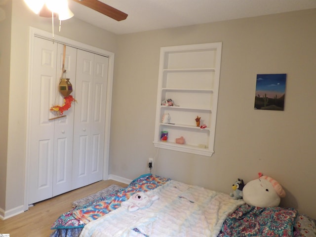 bedroom featuring a ceiling fan, light wood-type flooring, a closet, and baseboards