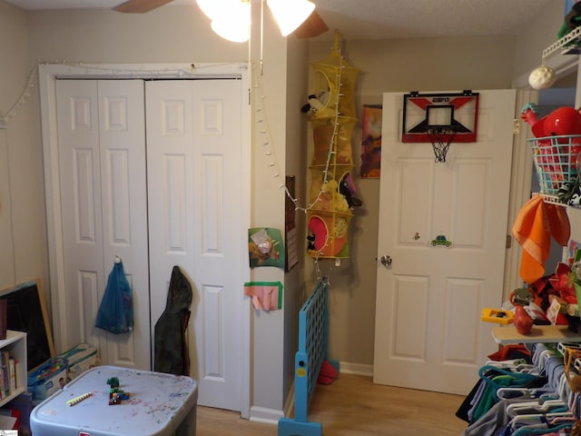 recreation room featuring ceiling fan, baseboards, and light wood-style floors