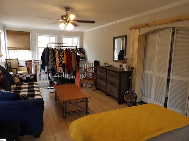 living room with ornamental molding, light wood finished floors, and a ceiling fan