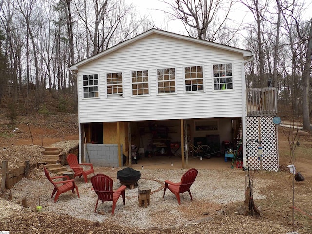 view of front of house with a patio, an outdoor fire pit, stairway, and a wooden deck