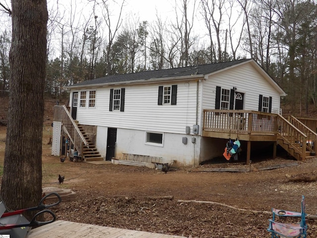 rear view of property featuring a wooden deck and stairs