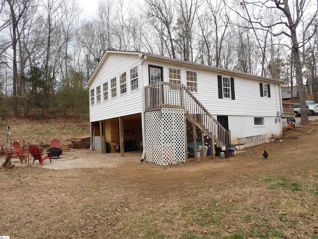 back of house with a garage, driveway, and stairway