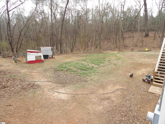 view of yard featuring stairway and a view of trees