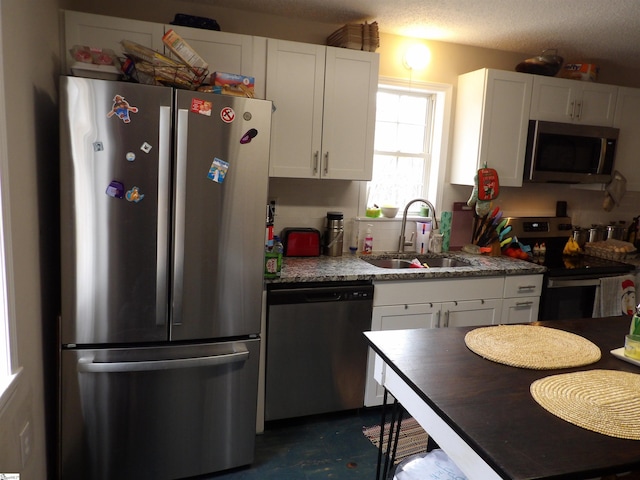 kitchen featuring white cabinetry, appliances with stainless steel finishes, and a sink