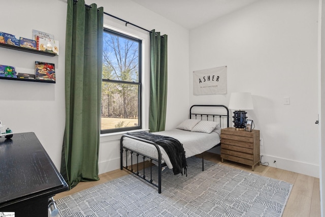 bedroom featuring baseboards and wood finished floors