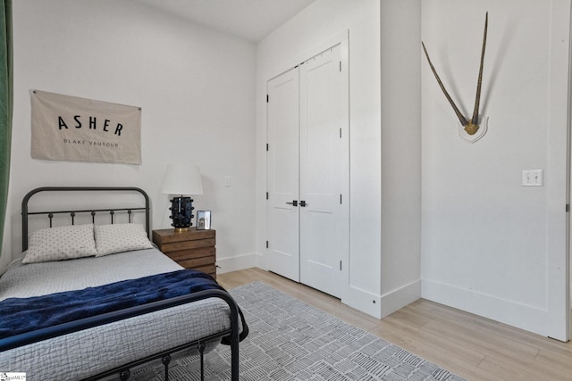 bedroom featuring a closet, baseboards, and wood finished floors