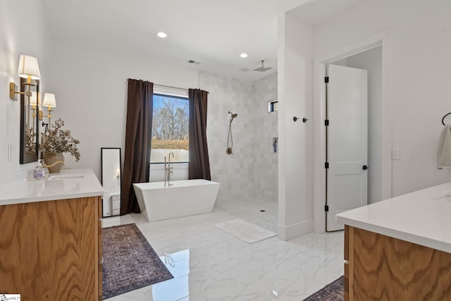 bathroom with marble finish floor, tiled shower, a soaking tub, and vanity