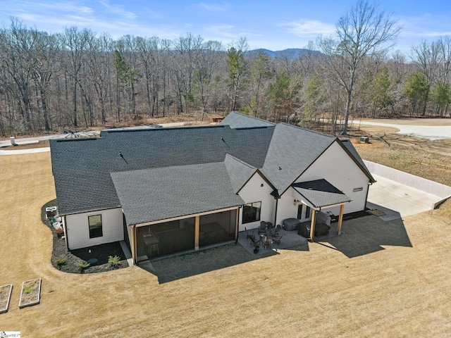 drone / aerial view with a wooded view