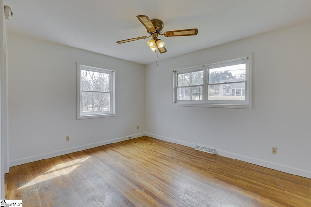 spare room with visible vents, baseboards, and hardwood / wood-style flooring