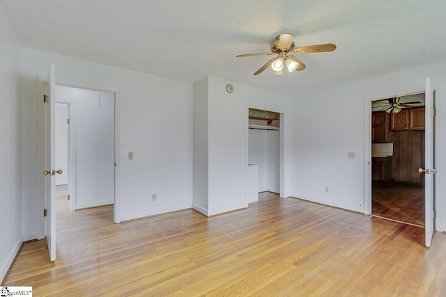 unfurnished bedroom featuring light wood-style floors, a ceiling fan, and a closet