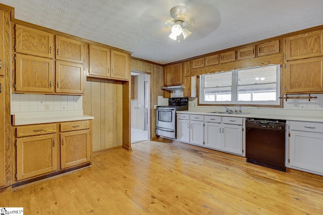 kitchen with black dishwasher, light wood-style floors, under cabinet range hood, stainless steel range with electric stovetop, and a sink