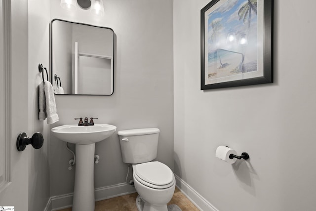 bathroom with tile patterned floors, a sink, toilet, and baseboards