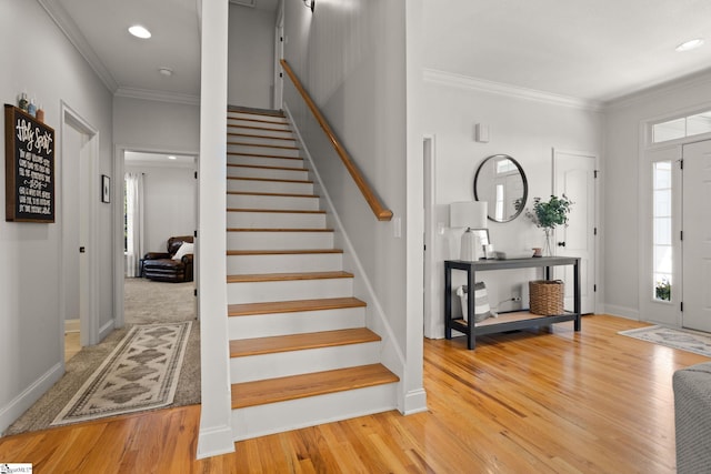 entrance foyer featuring light wood finished floors, stairs, baseboards, and crown molding