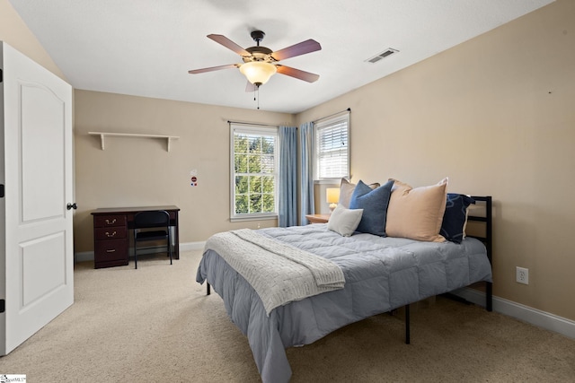 bedroom with a ceiling fan, light colored carpet, visible vents, and baseboards