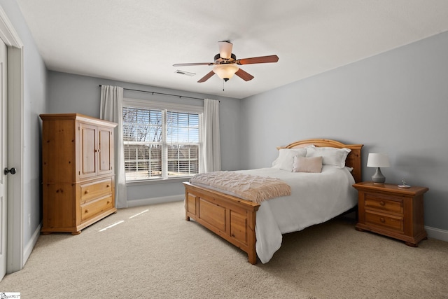 bedroom with baseboards, ceiling fan, visible vents, and light colored carpet