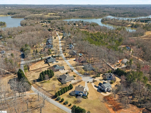 drone / aerial view with a water view and a forest view