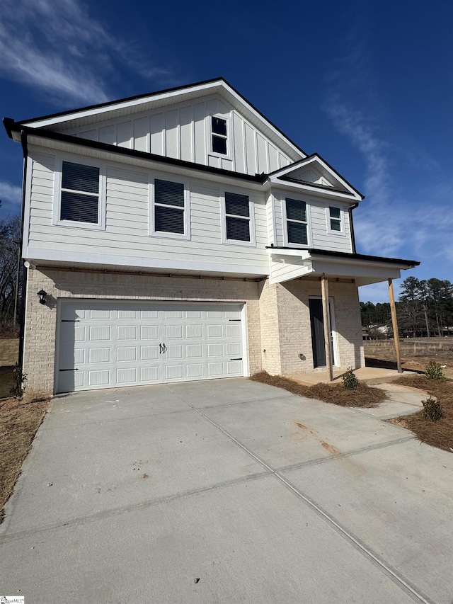 view of front of property featuring a garage, concrete driveway, board and batten siding, and brick siding