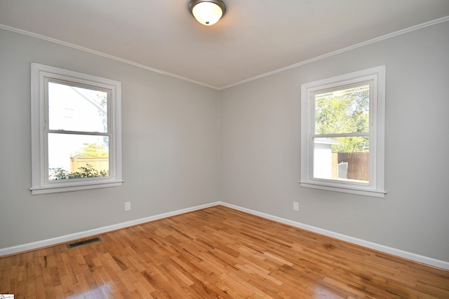 spare room featuring visible vents, crown molding, and baseboards