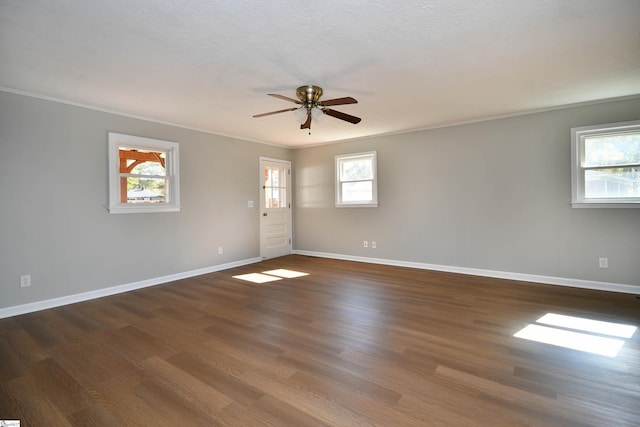 spare room with crown molding, baseboards, ceiling fan, and wood finished floors