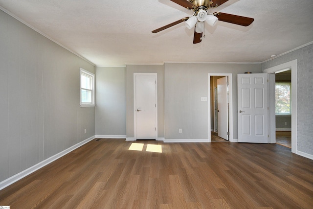 unfurnished bedroom featuring crown molding, baseboards, and wood finished floors