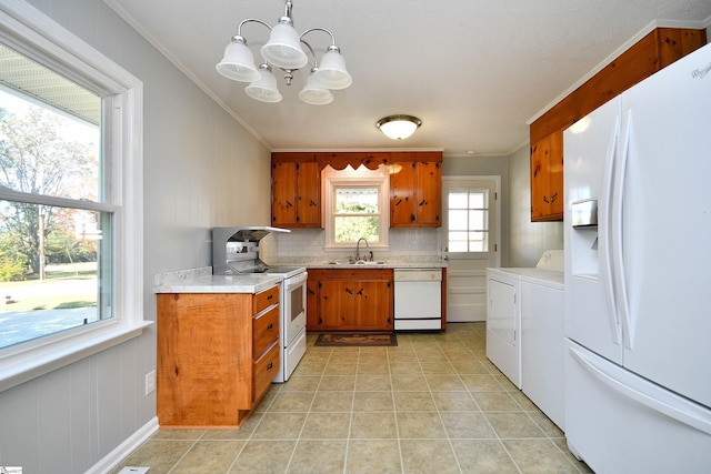 kitchen featuring light countertops, white appliances, brown cabinetry, and washing machine and dryer