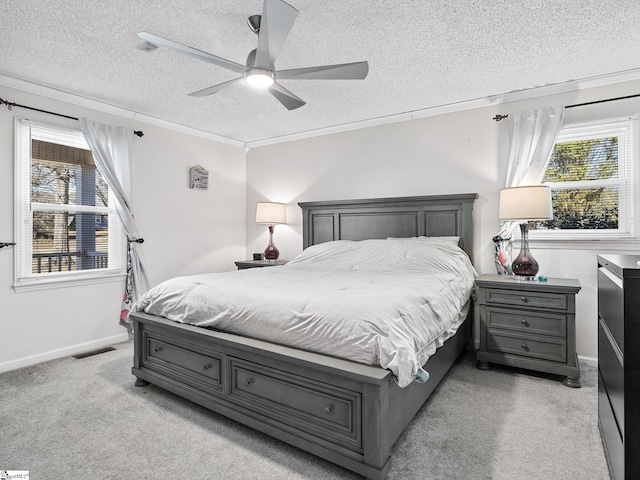 bedroom with baseboards, visible vents, light colored carpet, ornamental molding, and a textured ceiling