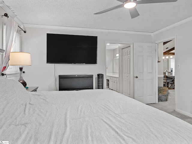 carpeted bedroom with a ceiling fan, ensuite bathroom, a textured ceiling, crown molding, and a fireplace