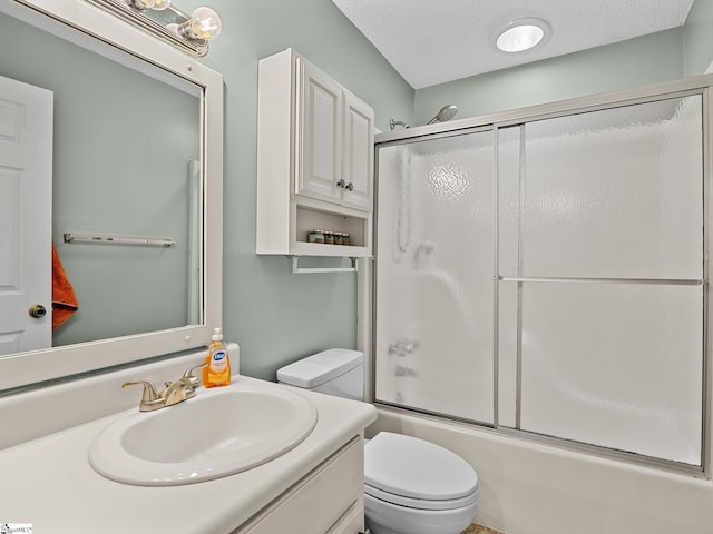 full bath with shower / bath combination with glass door, a textured ceiling, toilet, and vanity