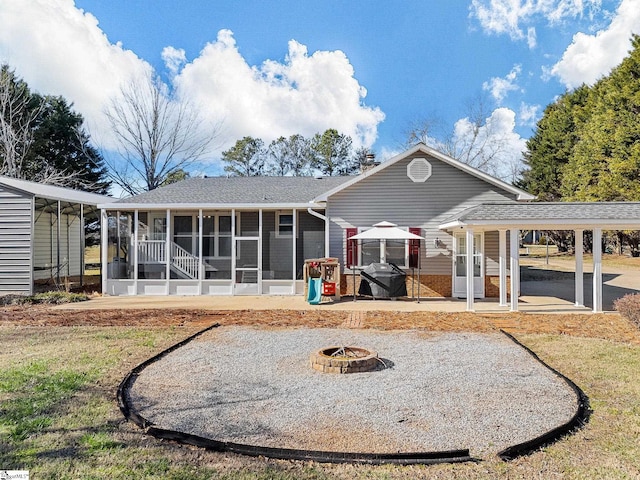 rear view of house featuring an outdoor fire pit, a sunroom, and a patio