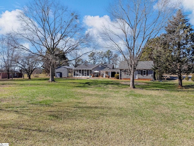 view of front facade featuring a front yard and a sunroom